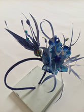 Load image into Gallery viewer, Sapphire blue feather and recycled plastic flowers on a blue silk covered band.