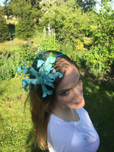 Load image into Gallery viewer, Turquoise and green recycled plastic flower on a turquoise silk metal covered headband.